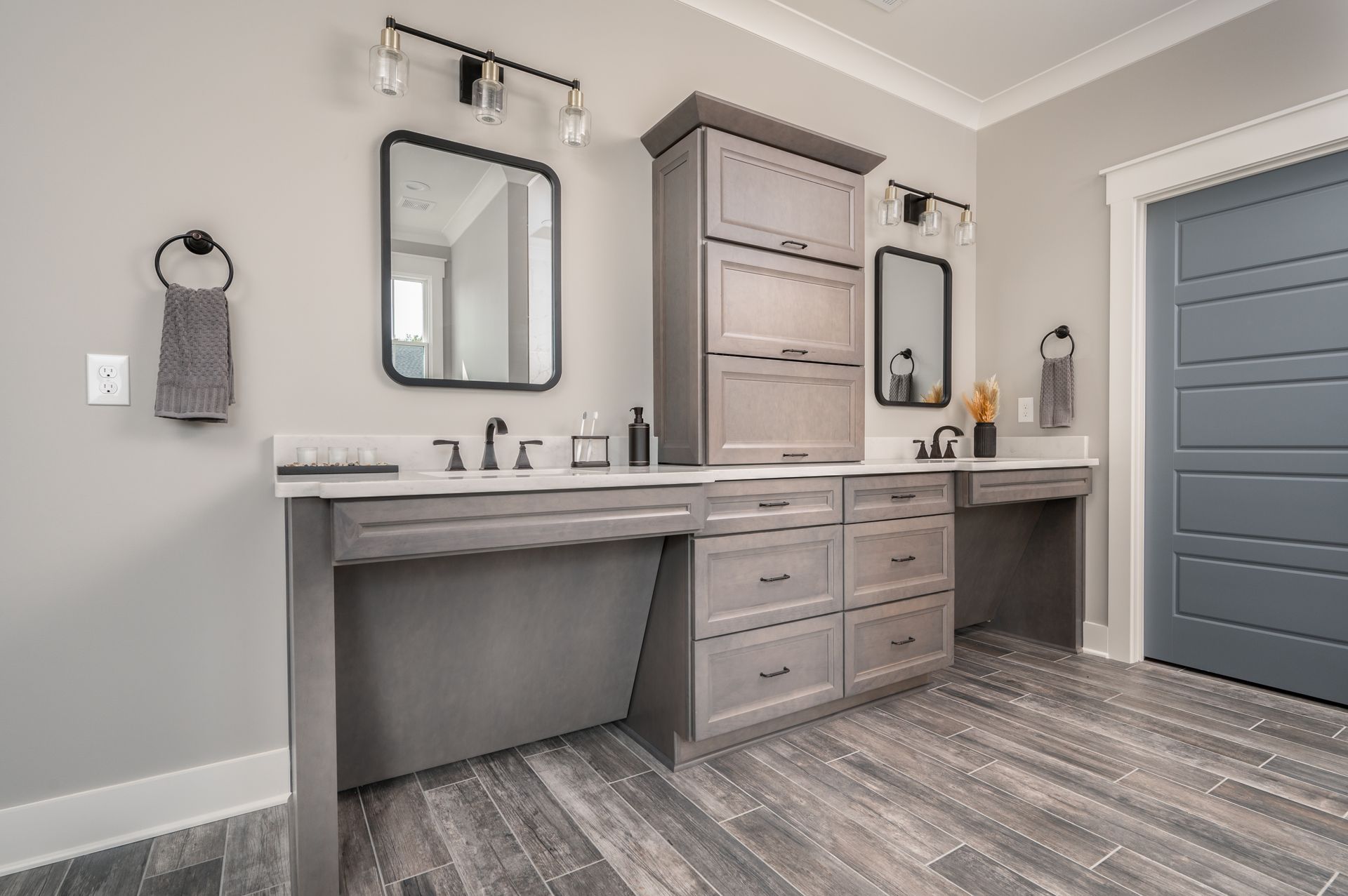 A bathroom with two sinks , two mirrors , and a blue door.