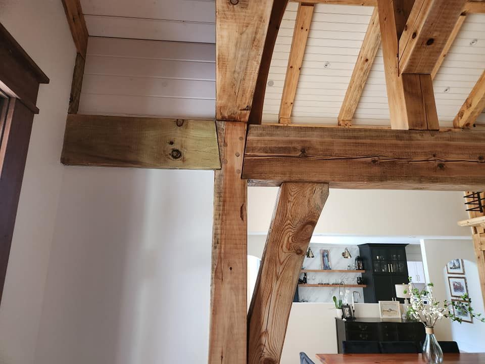 A dining room with wooden beams and a table
