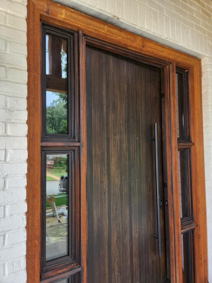 A wooden door with two windows on a white brick wall.