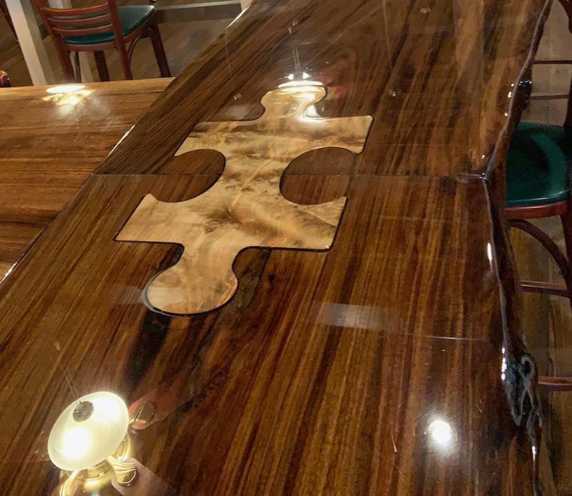 A wooden table with a puzzle piece on it