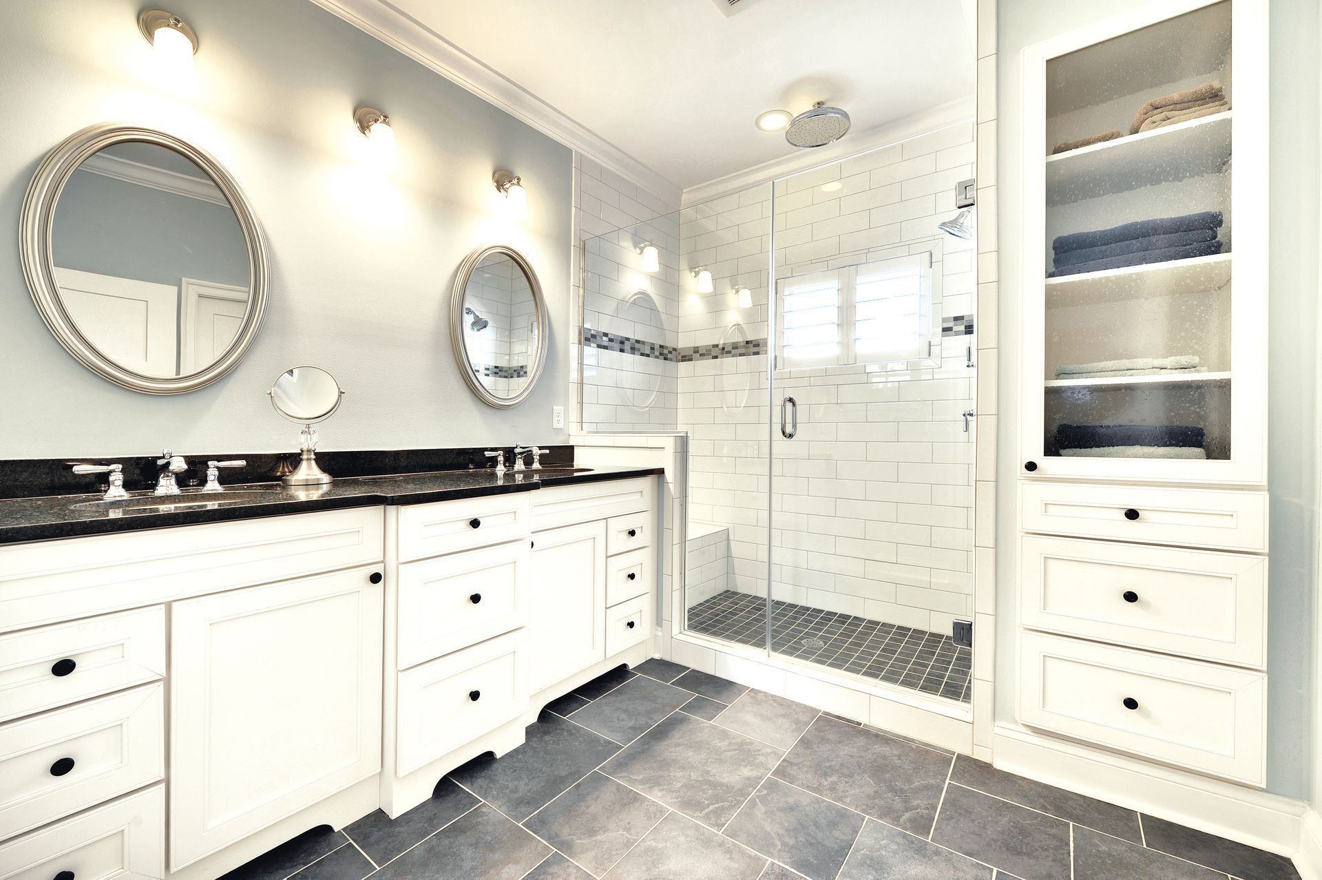A bathroom with two sinks and a walk in shower.