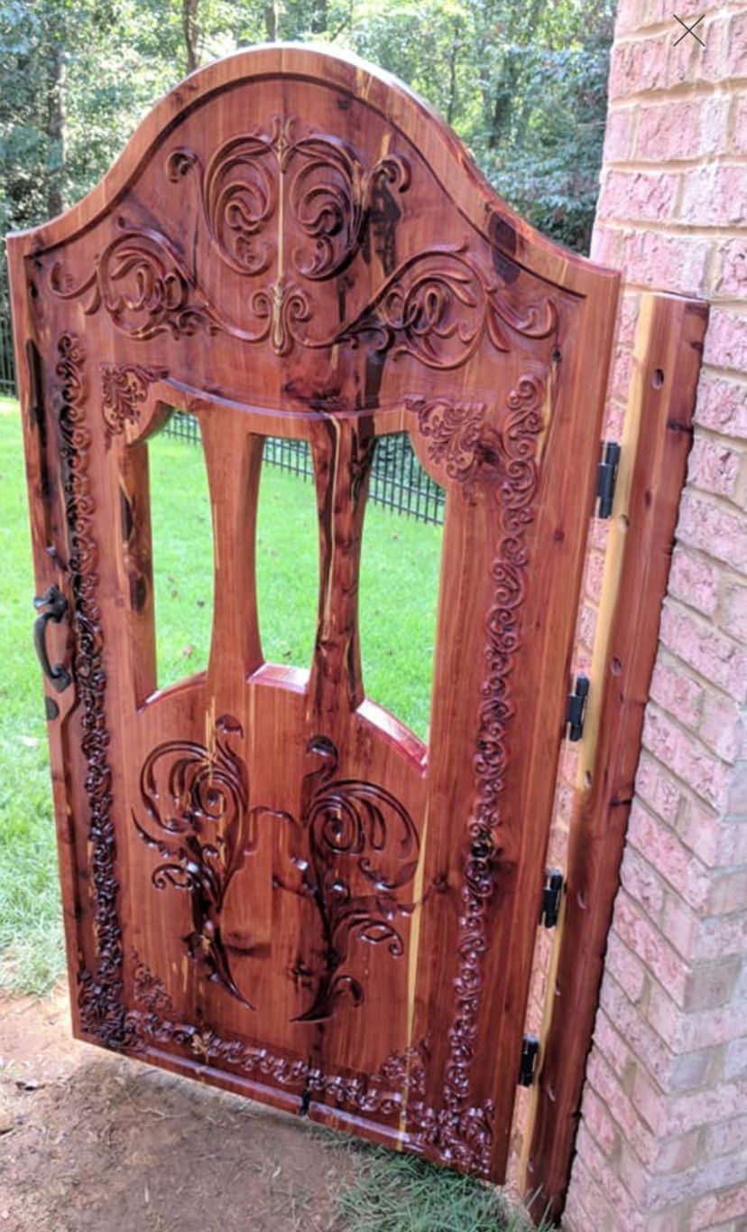 A wooden gate is sitting on the side of a brick building.