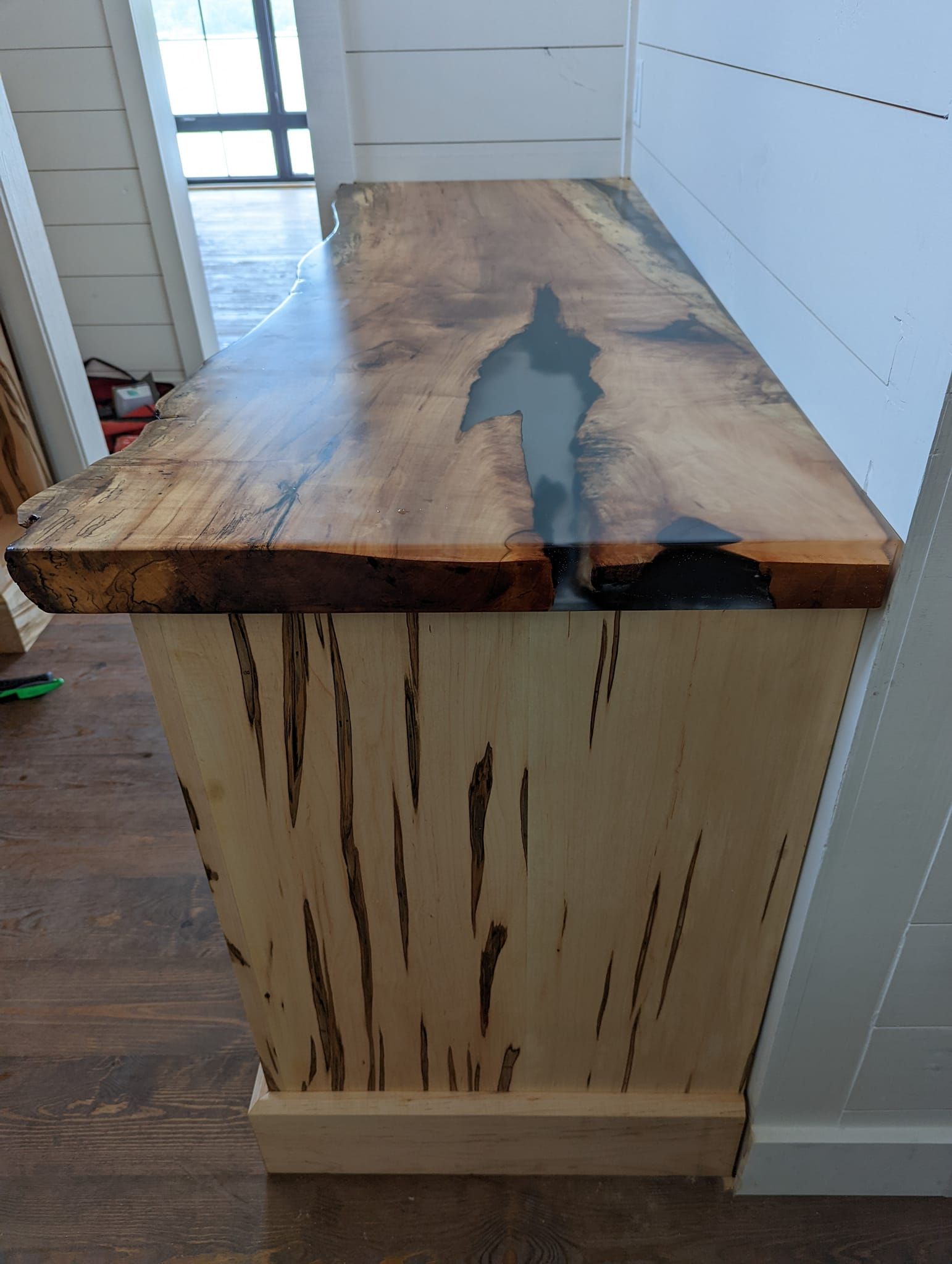 A wooden table with a wooden top is sitting on a wooden floor in a room.