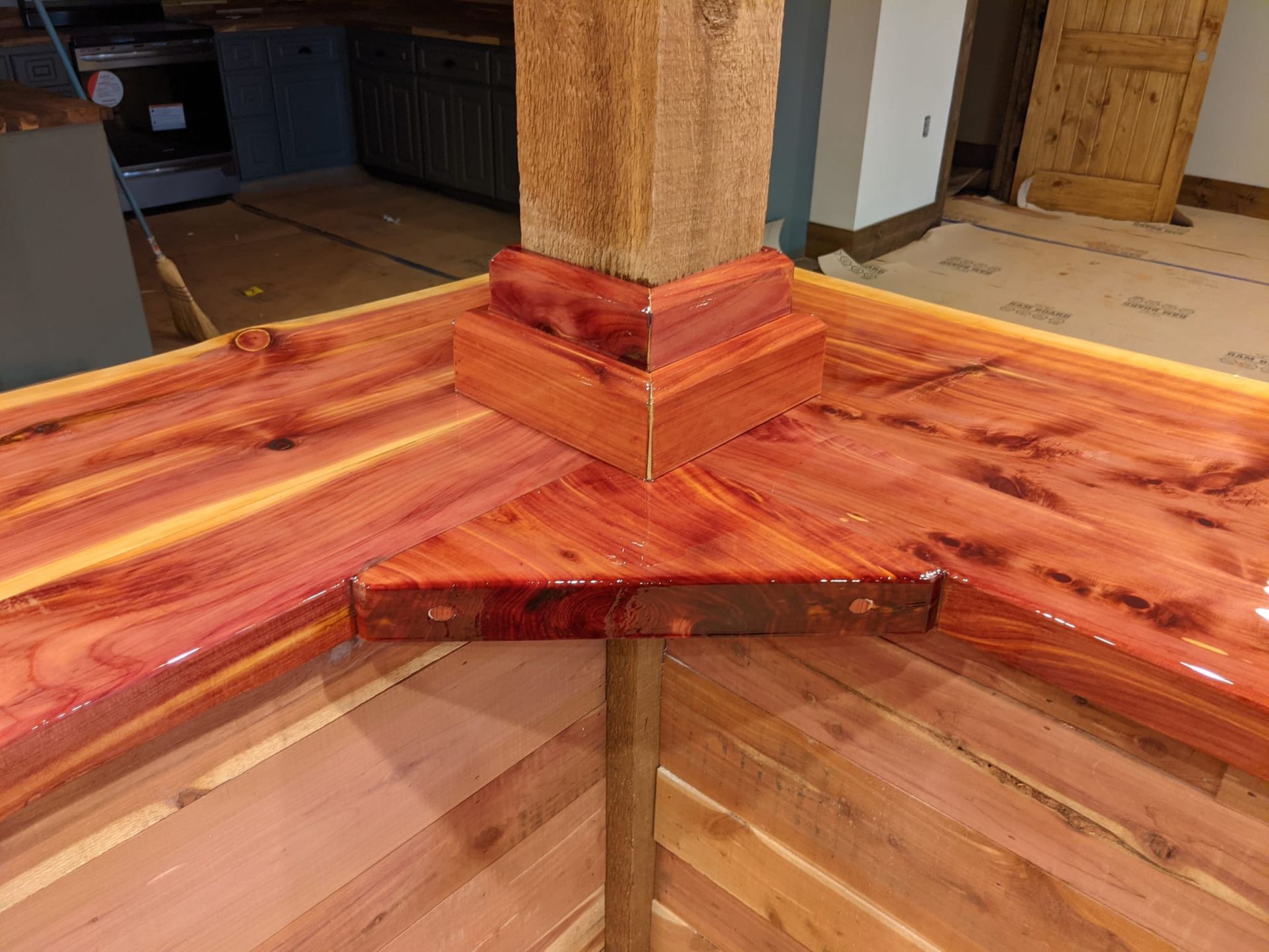 A wooden table with a wooden post in the corner of a room.