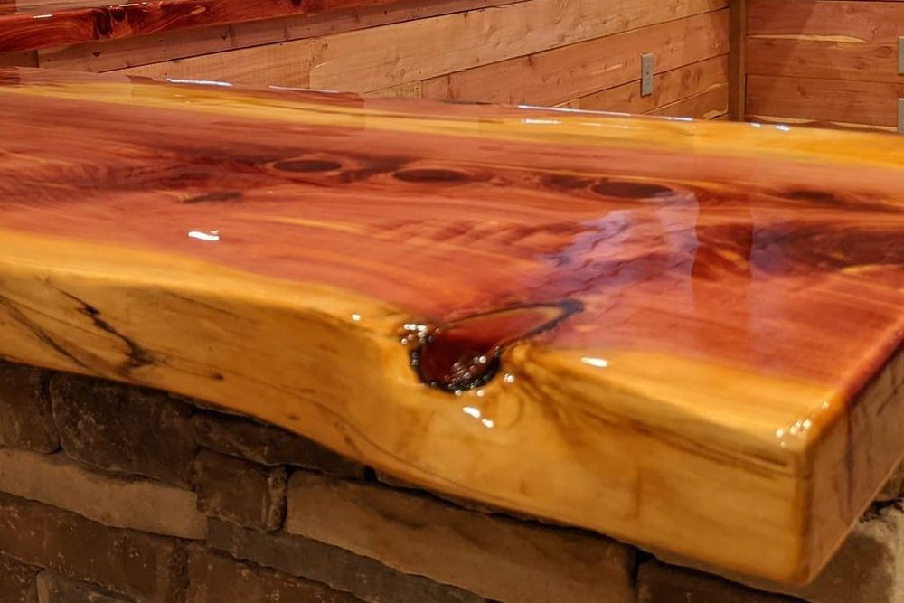 A close up of a wooden counter top with a brick wall in the background.