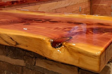 A close up of a wooden counter top with a brick wall in the background.