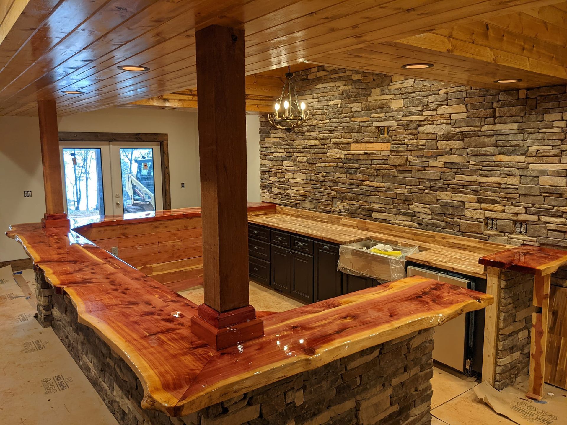 A kitchen with a wooden counter top and a stone wall.