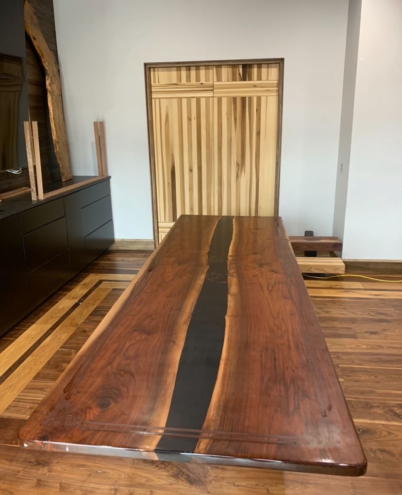 A long wooden table is sitting in a room next to a door.