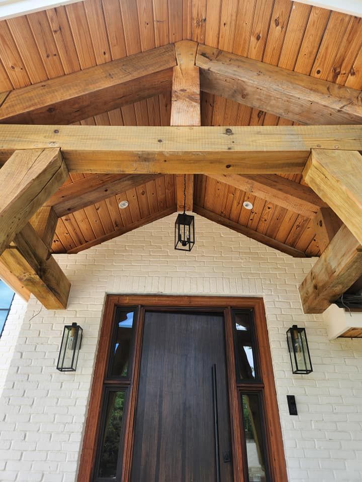The front door of a house with a wooden roof and wooden beams.