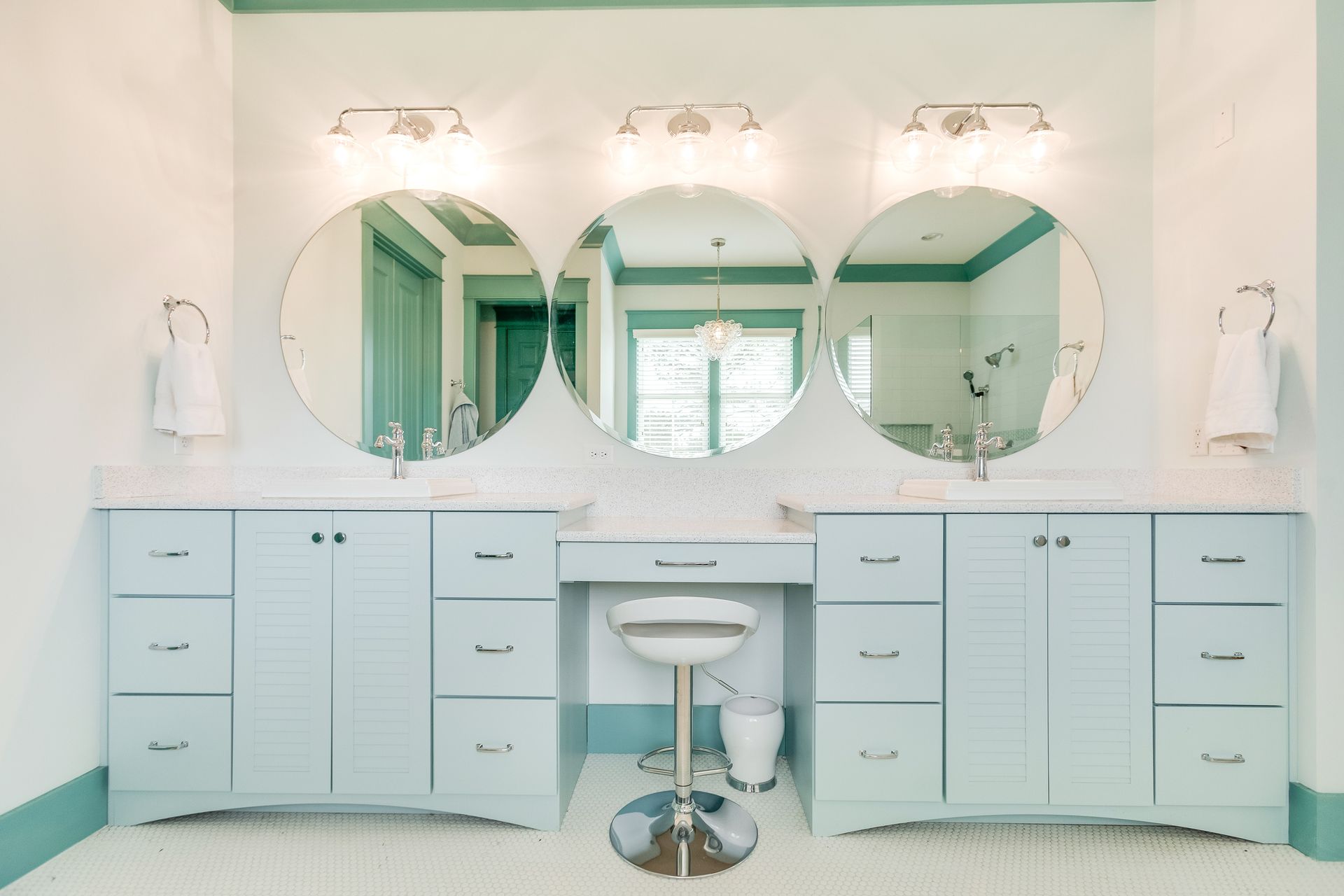 A bathroom with two sinks and three mirrors.