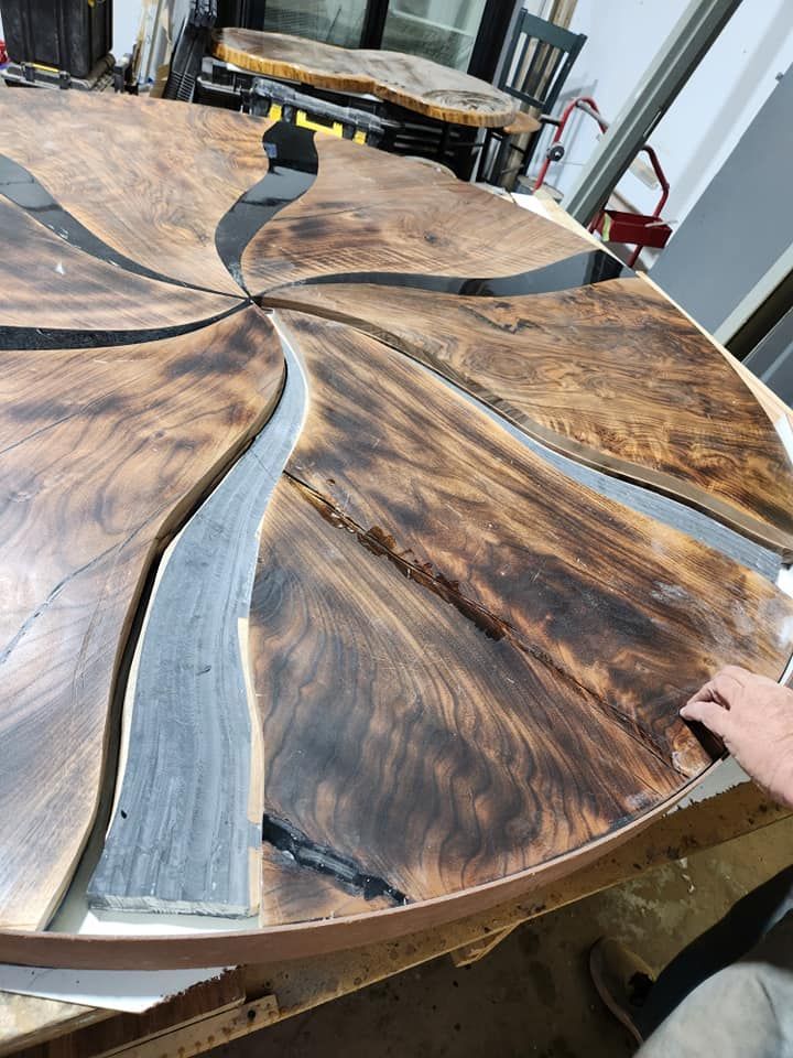 A person is working on a wooden table in a workshop.
