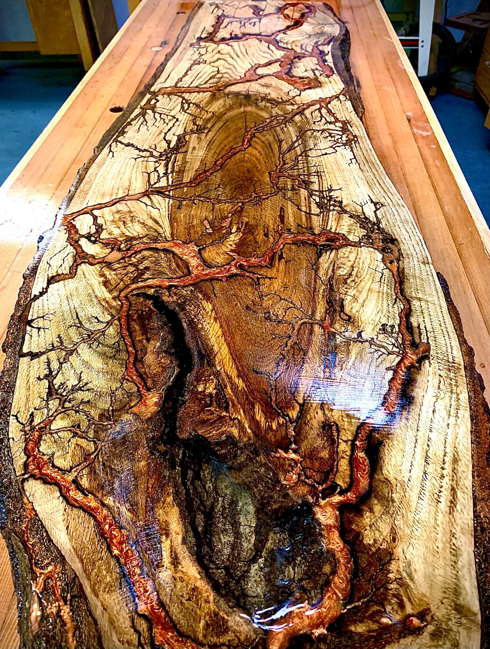 A large piece of wood is sitting on top of a wooden table.