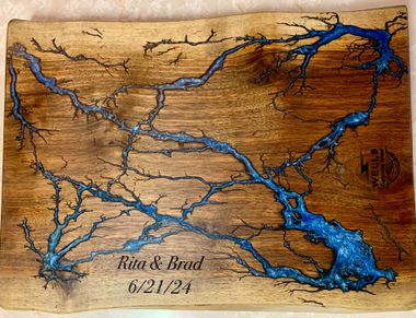 A wooden cutting board with a picture of a river on it