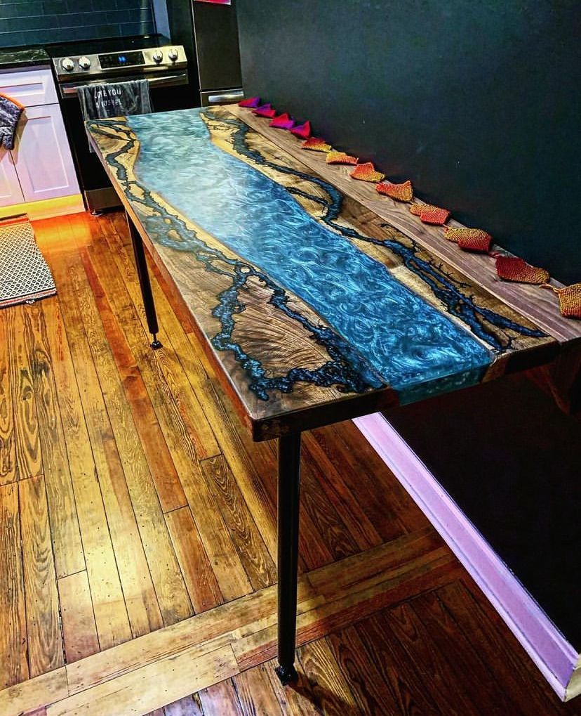 A wooden table with a blue river on it in a kitchen.