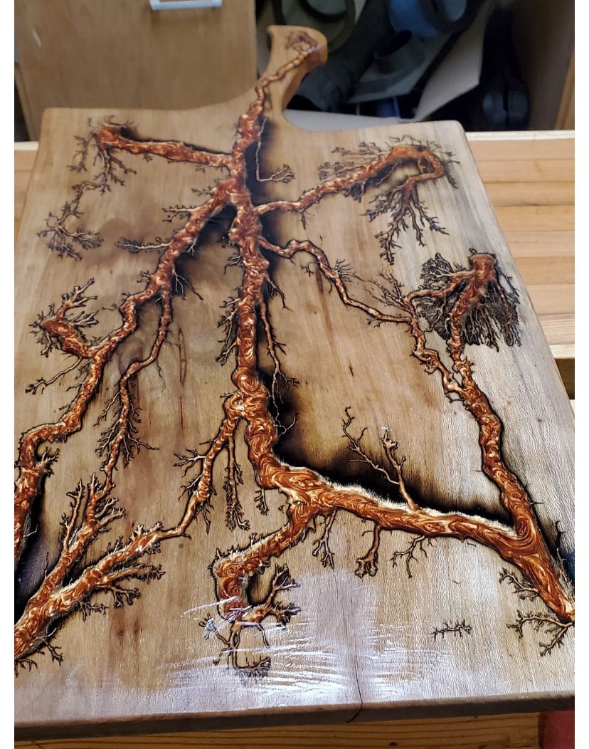 A wooden cutting board with a picture of a tree on it.