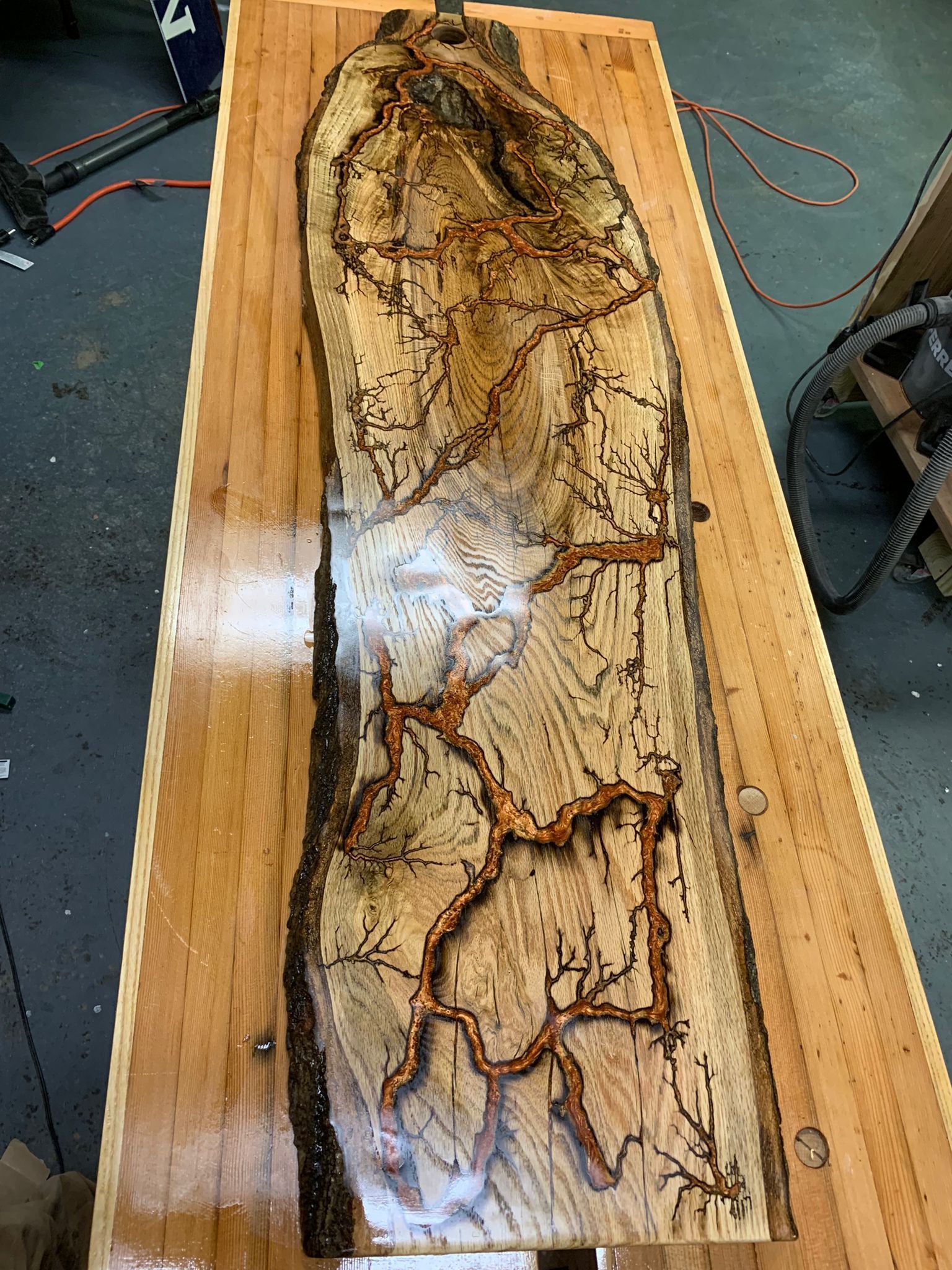 A large piece of wood is sitting on top of a wooden table.