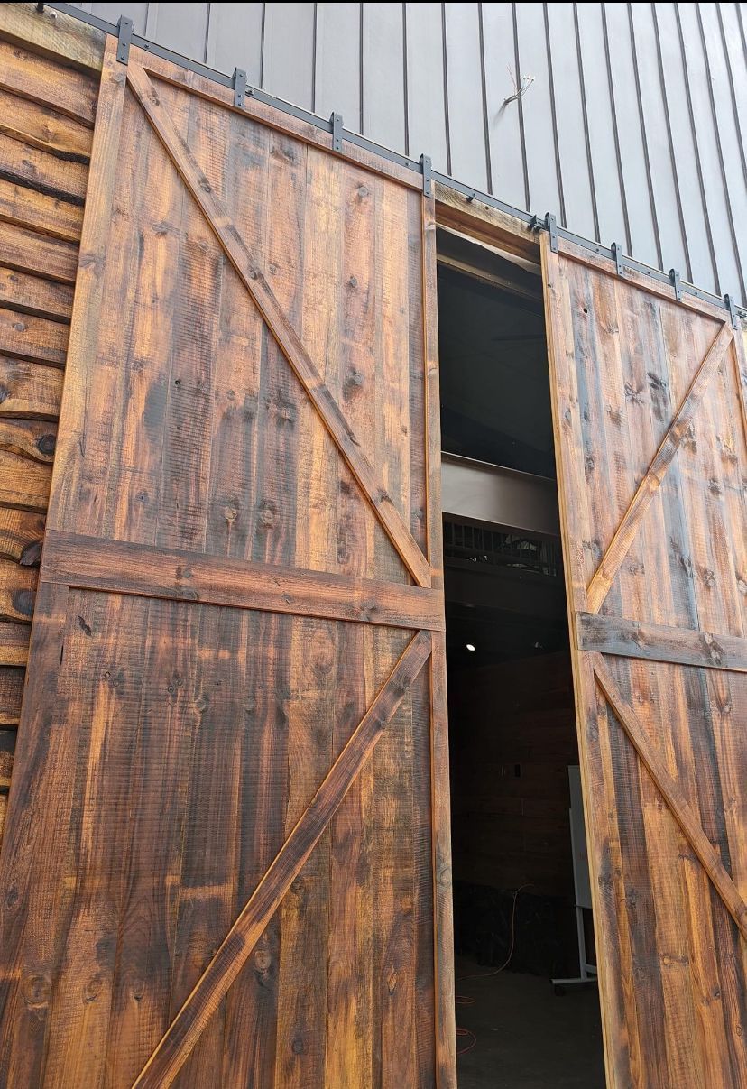 A close up of a wooden barn door with the door open.