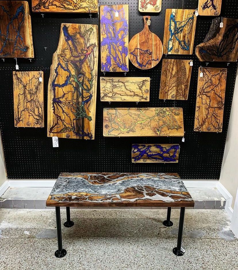 A wooden table is sitting in front of a wall with paintings on it