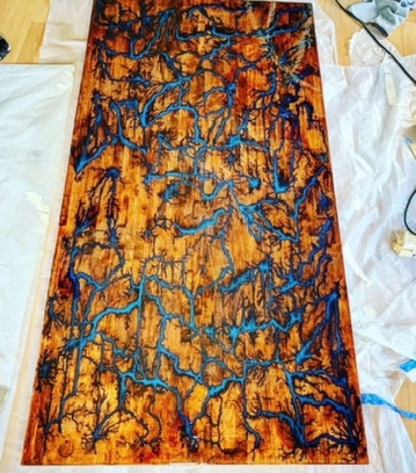 A piece of wood with a painting of trees on it