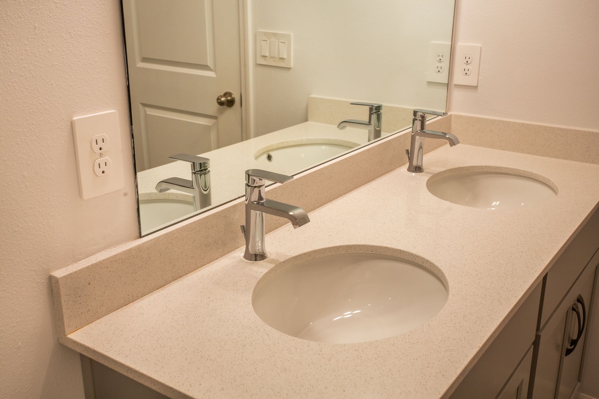 A bathroom with two sinks and a mirror.