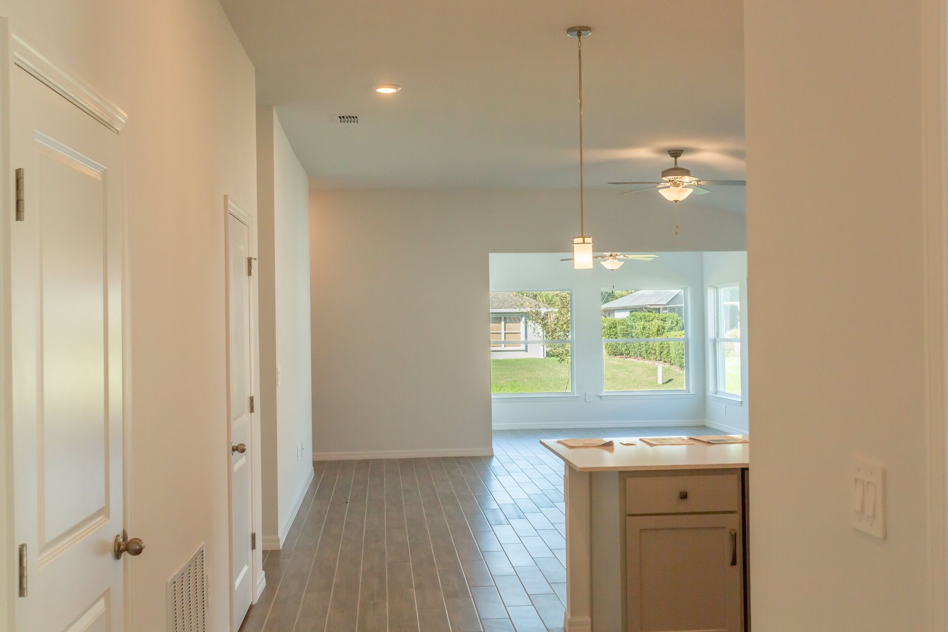 A hallway in a house leading to a kitchen and living room.