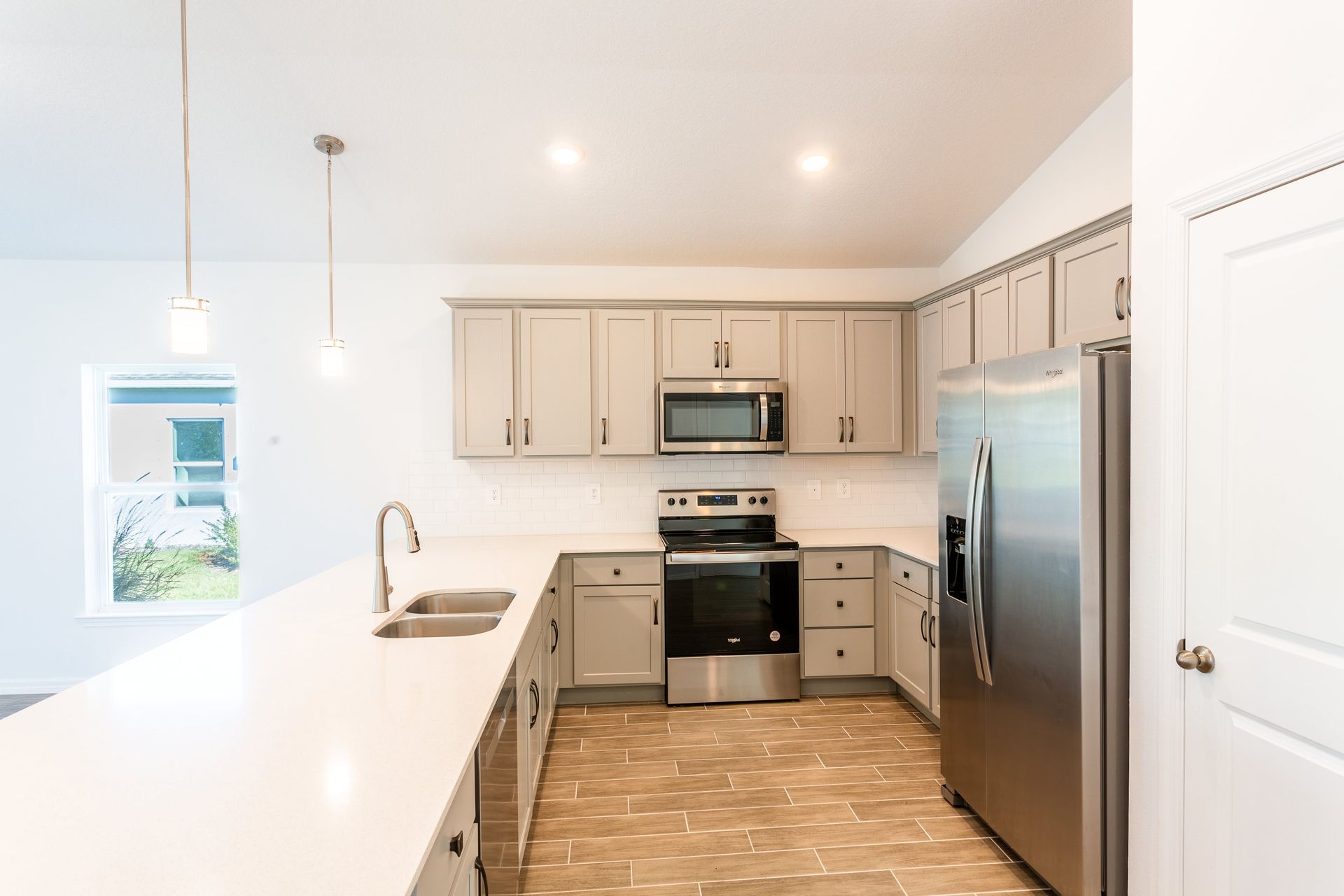 A kitchen with stainless steel appliances and white cabinets