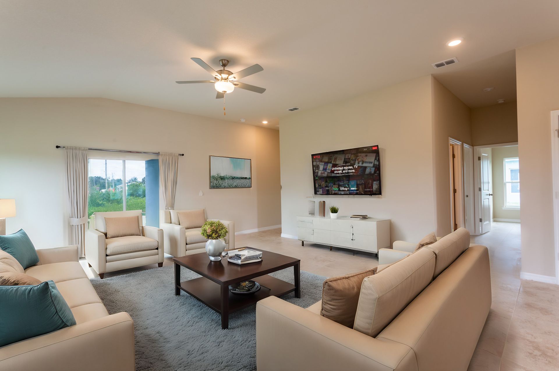 A living room filled with furniture and a ceiling fan.