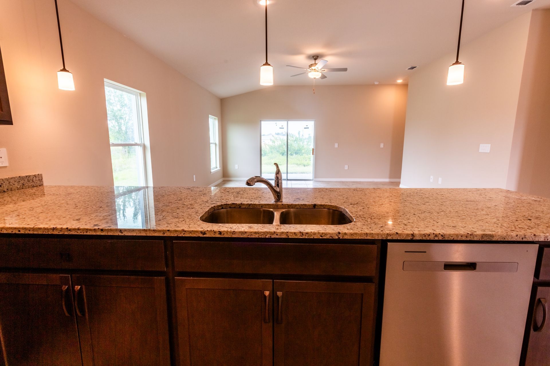 A kitchen with a granite counter top and a stainless steel dishwasher.