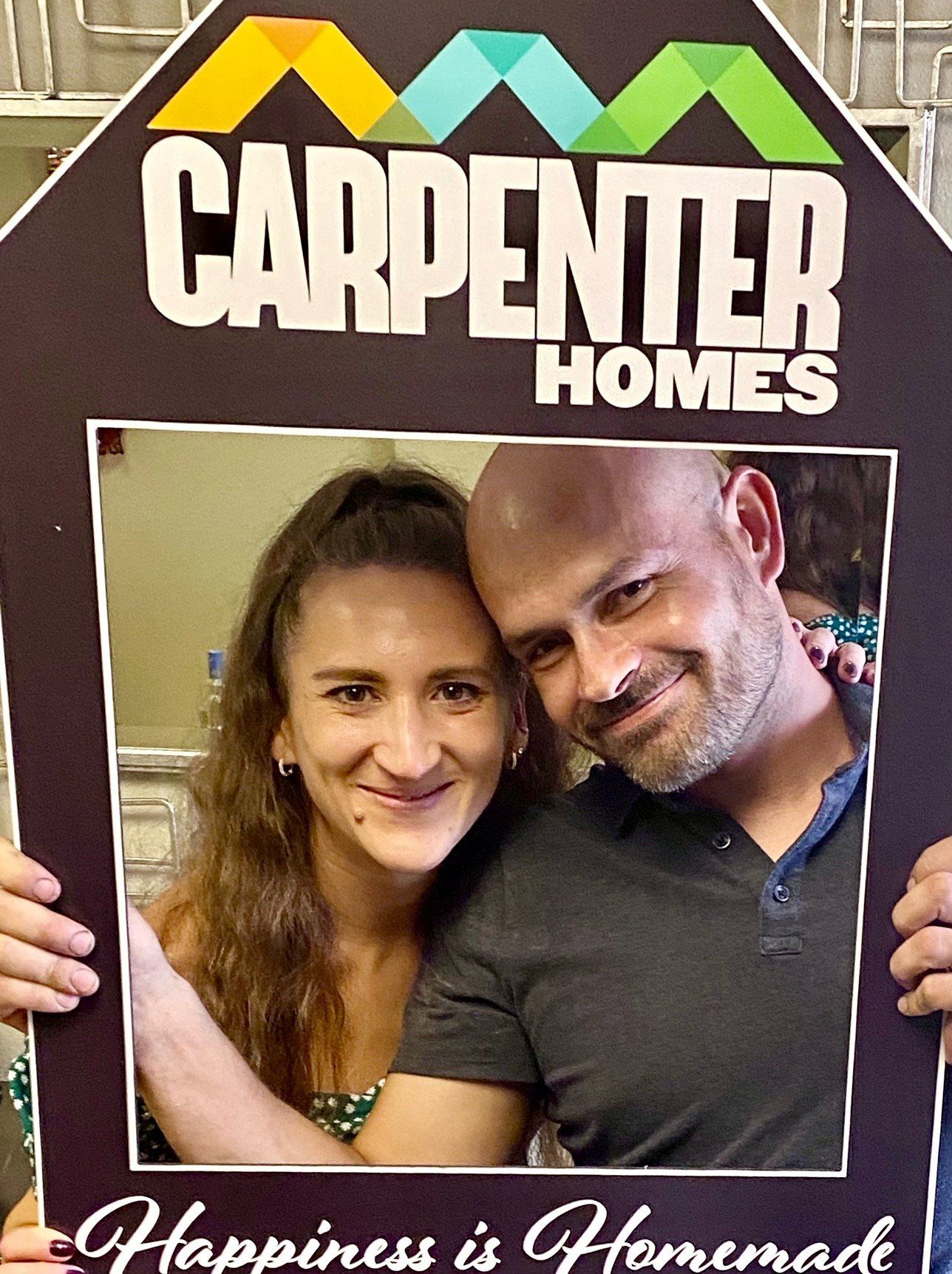 Eugene and Sveta Holding Carpenter Homes Sign
