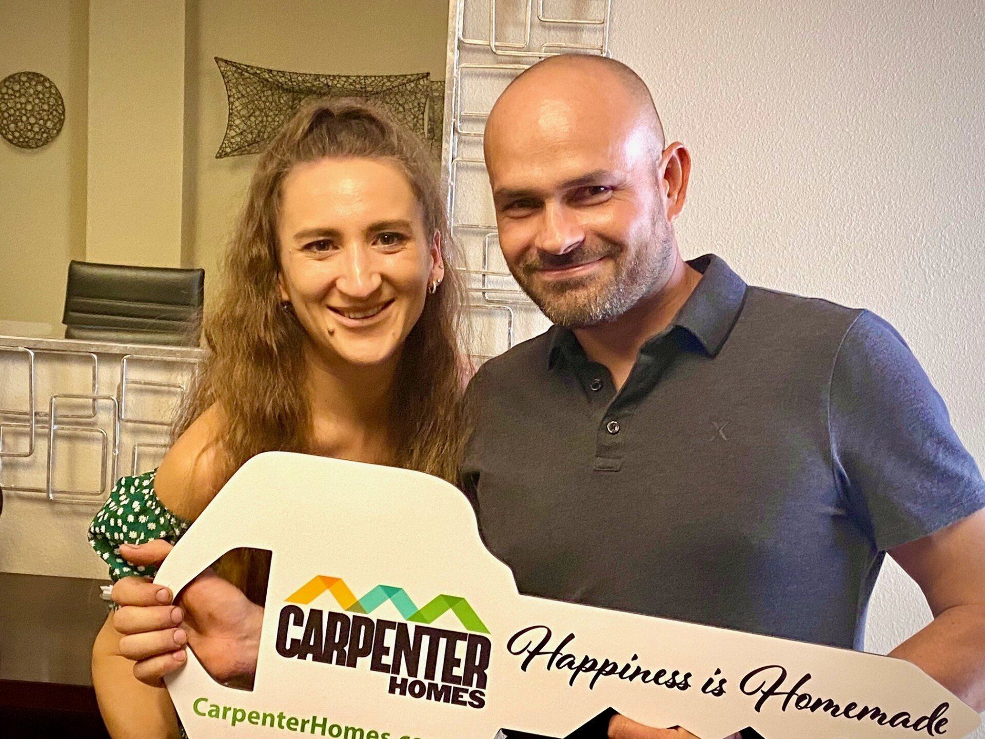 Eugene and Sveta Holding Carpenter Homes Sign