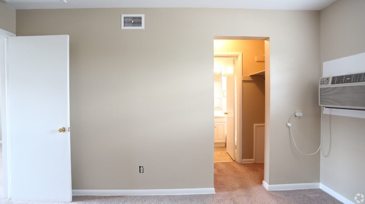 An empty room with a doorway leading to a walk in closet