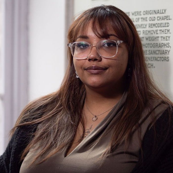 A woman without a face is wearing a suit and white shirt