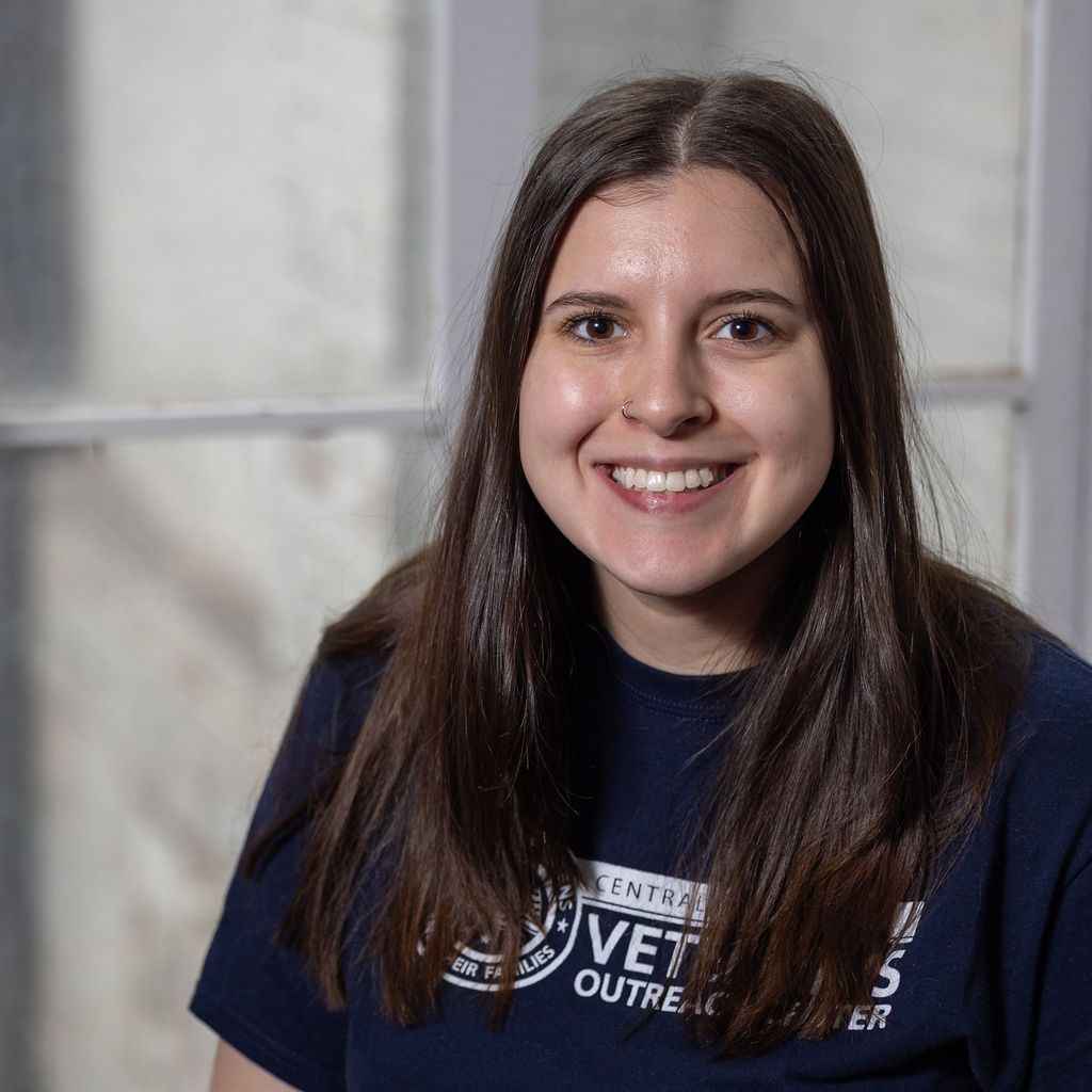 A woman without a face is wearing a suit and white shirt