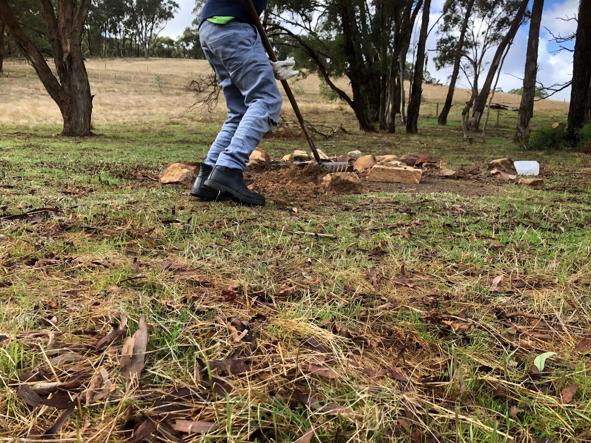 A person raking a firepit