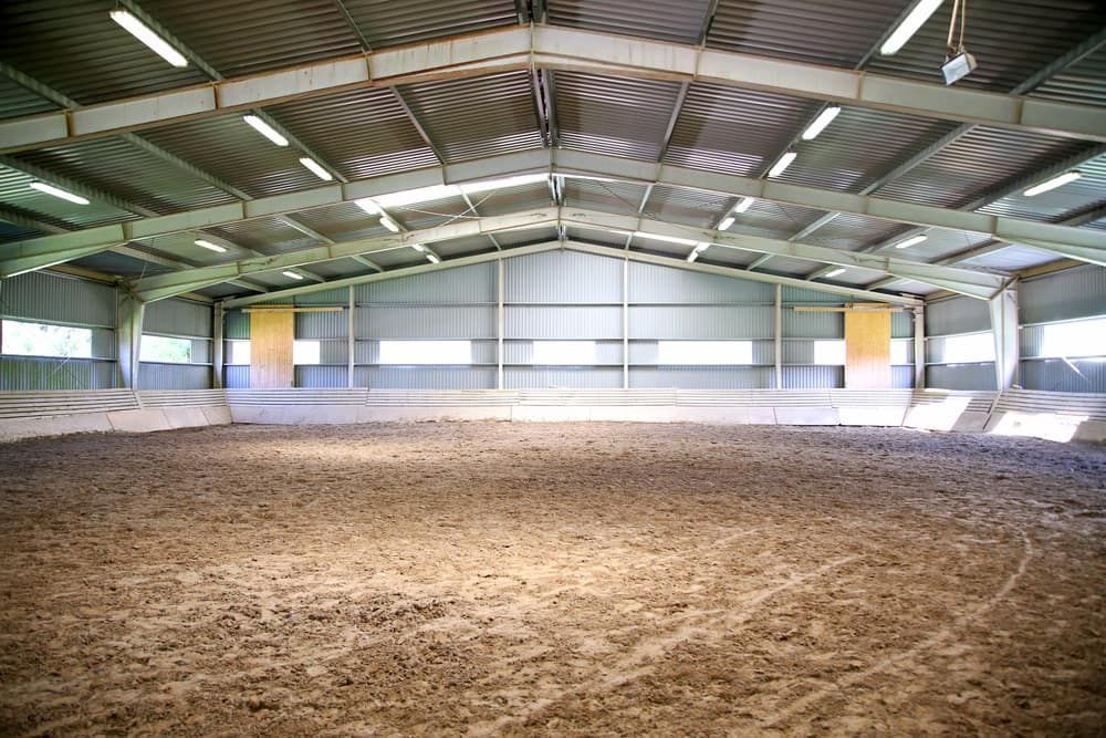 A Large Indoor Arena With a Lot of Dirt in It — Meraki Equestrian Centre in Mareeba, QLD