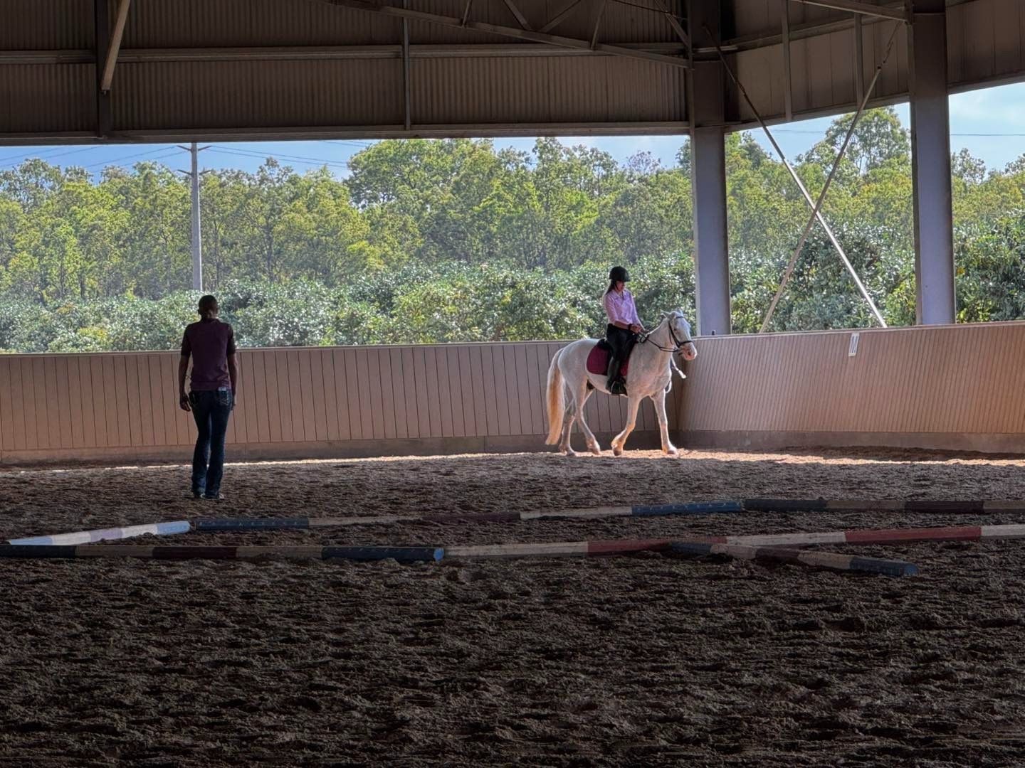 Person Riding a Horse With Trainer
