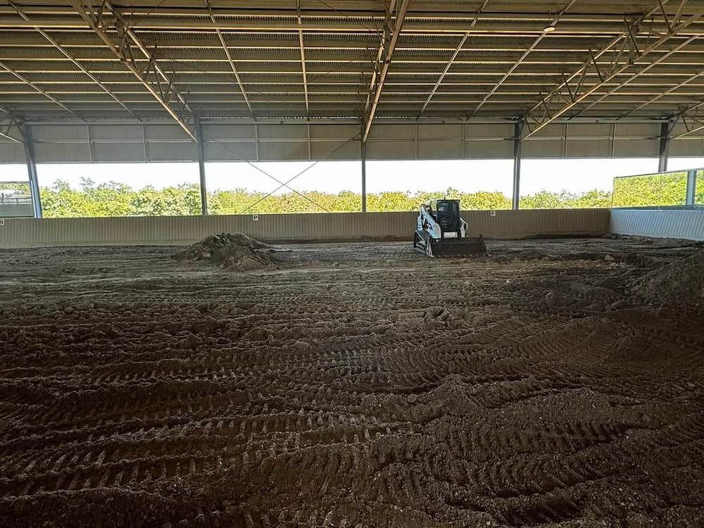 A Bulldozer is Moving Dirt in a Large Warehouse — Meraki Equestrian Centre in Mareeba, QLD