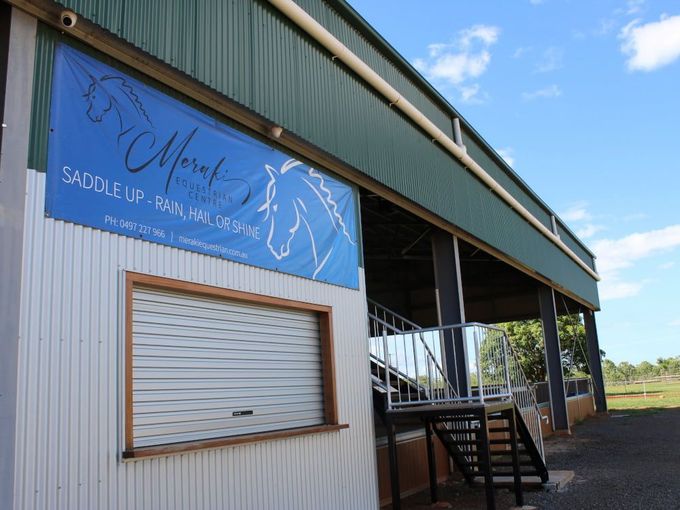 A Building With a Sign That Says Saddle Up on It — Meraki Equestrian Centre in Mareeba, QLD