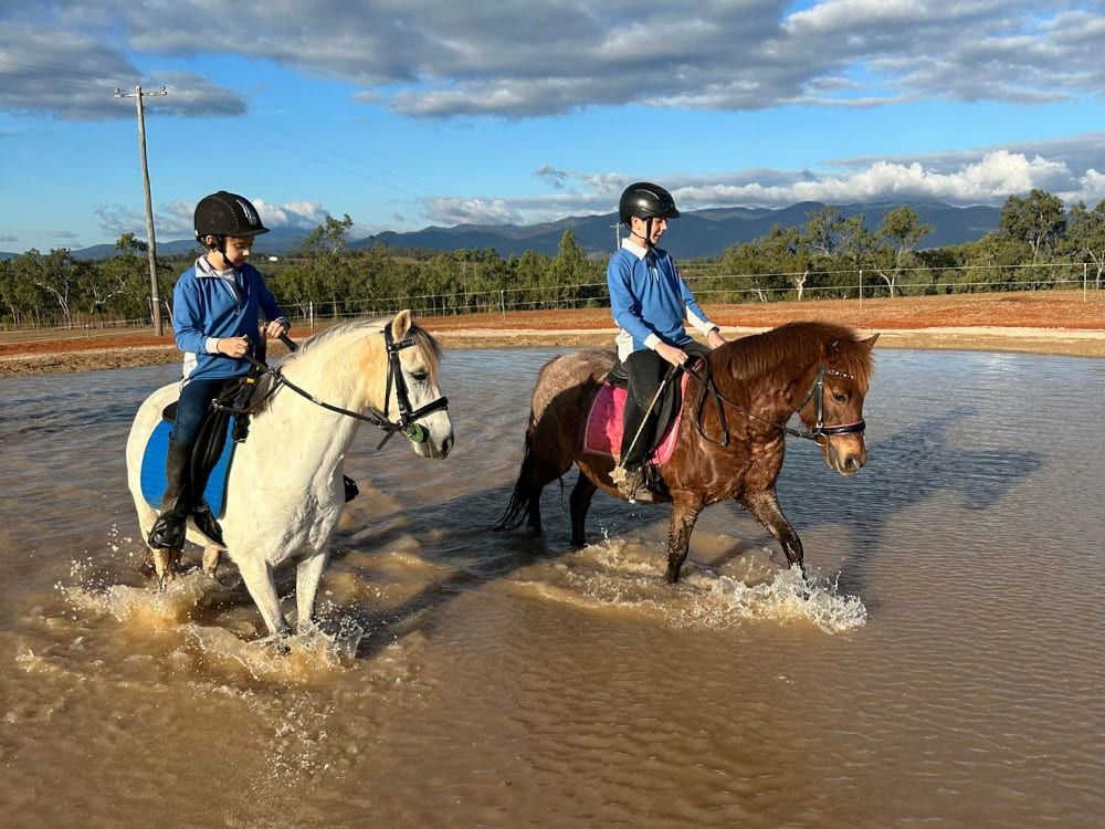 Two Children Are Riding Horses in the Water — Meraki Equestrian Centre in Mareeba, QLD