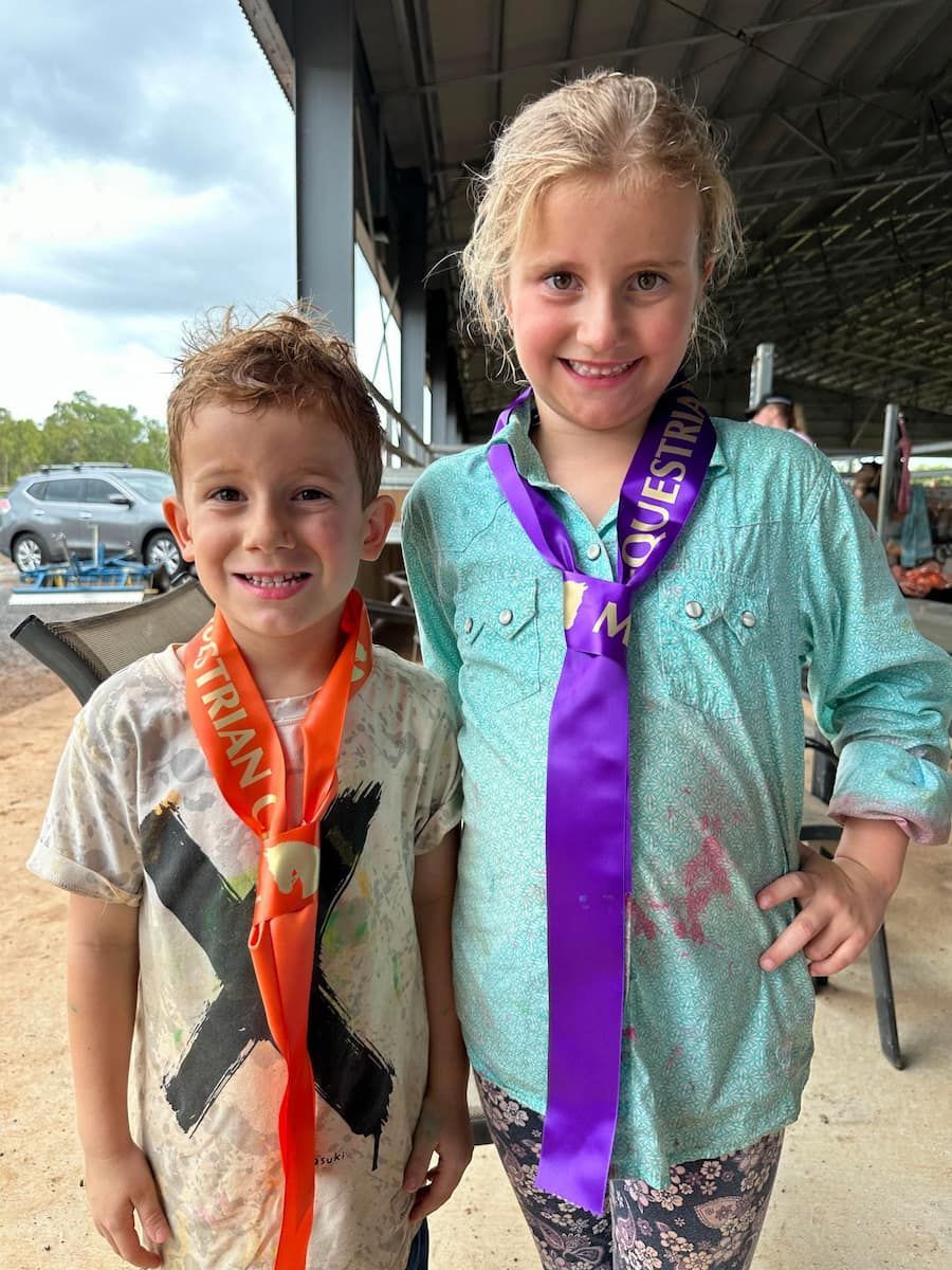 A Boy and a Girl Are Standing Next to Each Other Wearing Medals — Meraki Equestrian Centre in Mareeba, QLD