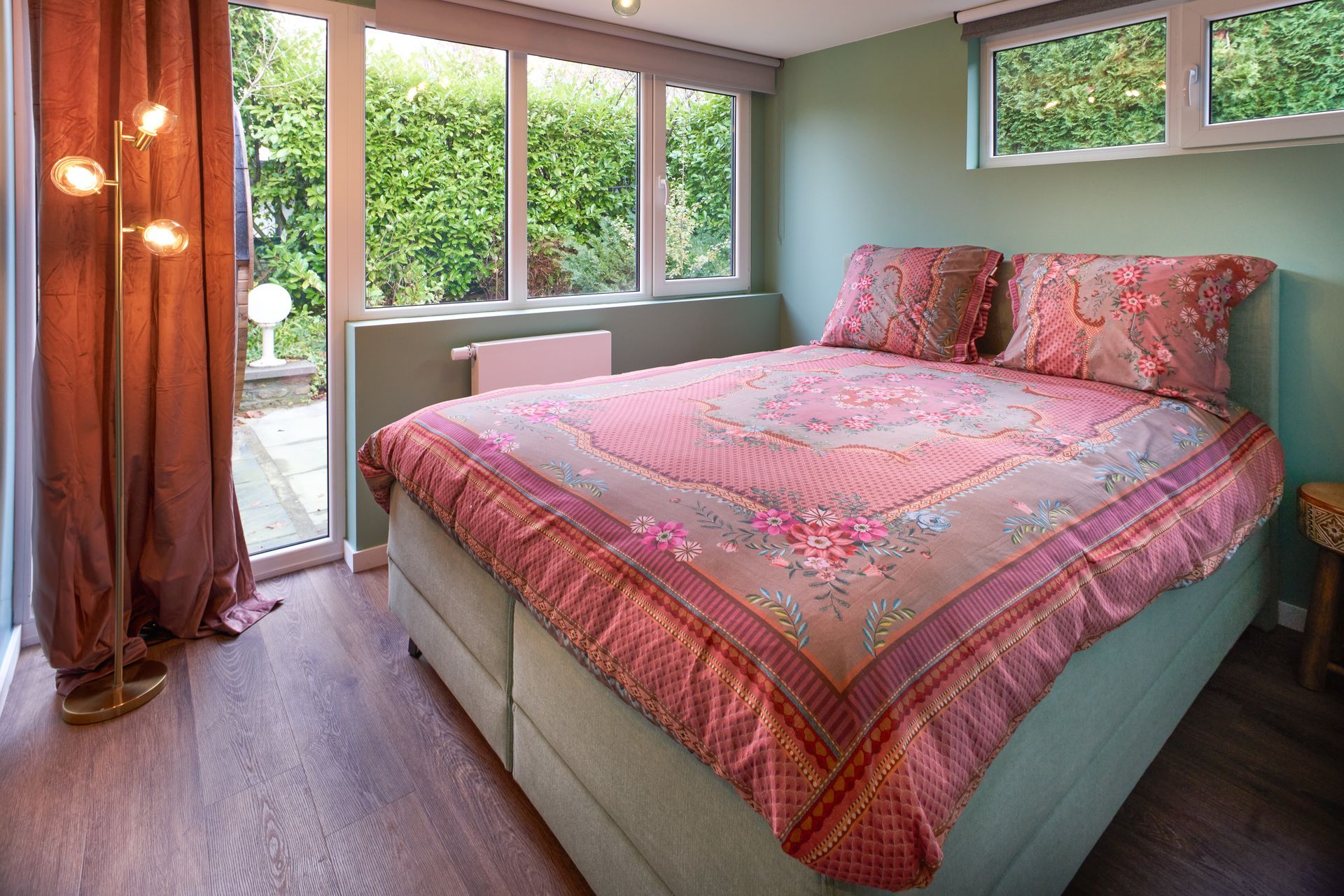 a bed with a pink floral comforter and pillows - Lacuna Vitta holiday home