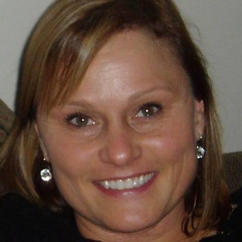 A woman wearing earrings is smiling for the camera.