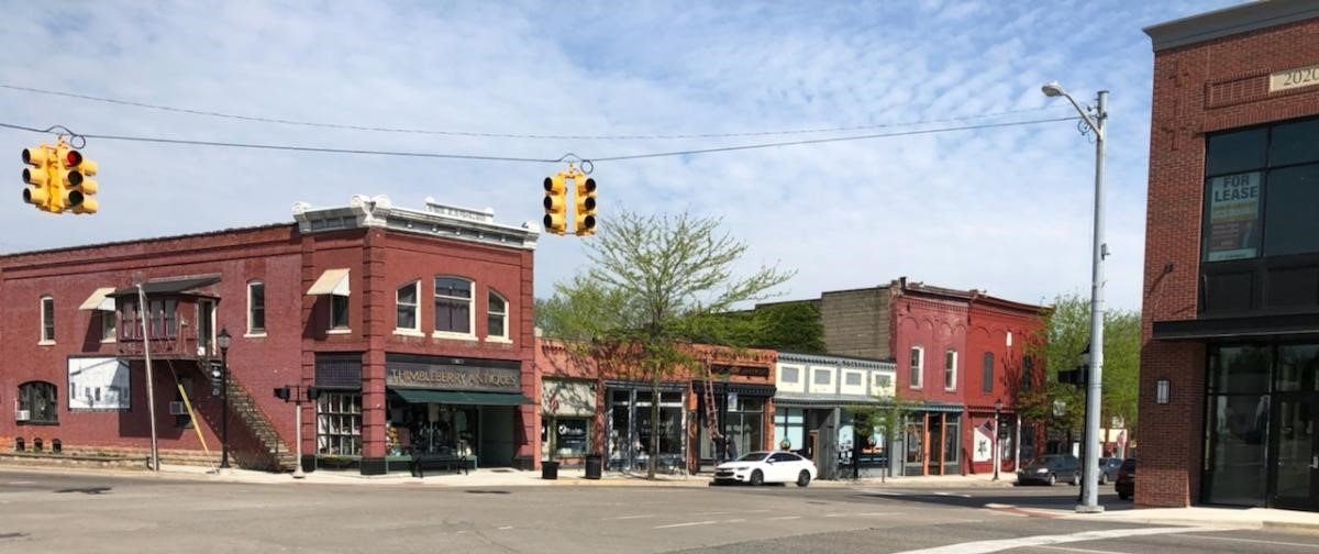 A city street with a lot of buildings and traffic lights.