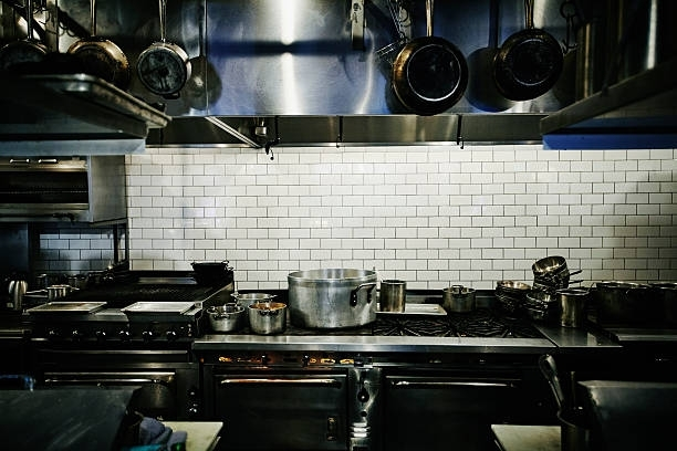 Pots simmering on range in restaurant kitchen before dinner service