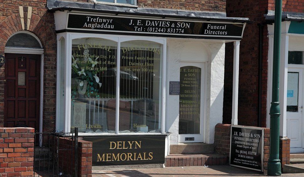 The front of the Connaghs Quay office, with flowers and memorials in the window