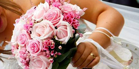 A bride holding a bouquet of pink flowers
