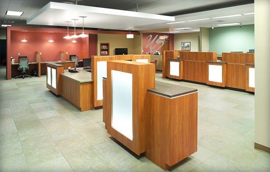 A large room with lots of wooden desks and cubicles