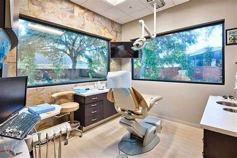 A dental office with a dental chair and a large window.