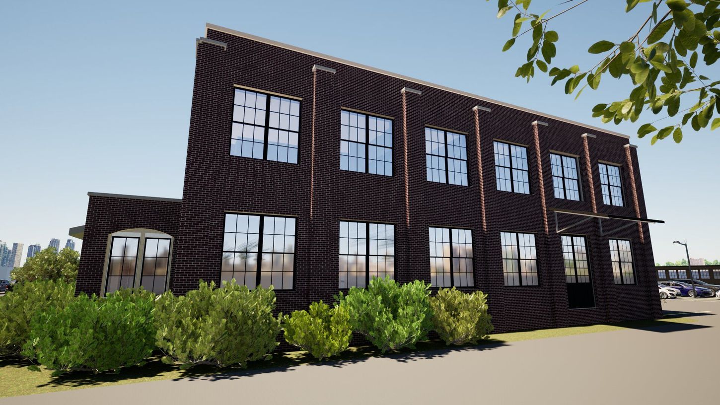 A large brick building with lots of windows is surrounded by trees and bushes.
