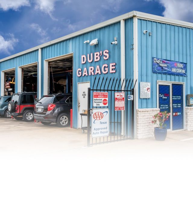 Blue auto repair shop with open garage bays and a white storefront under a clear sky | Dub's Garage